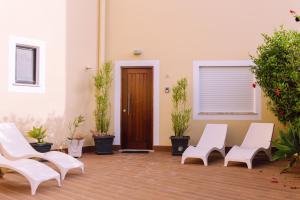 ラゴスにあるAurora Housesの白い椅子と鉢植えの植物が備わる部屋