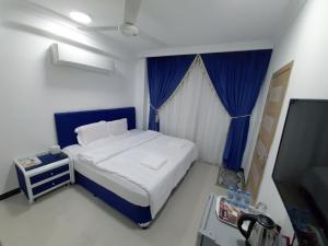 a small bedroom with a bed and a tv at Al Rayyan Hotel Apartments Muscat in Seeb