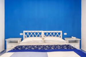 una camera blu con un letto bianco e una parete blu di Hotel Metropole a Sorrento