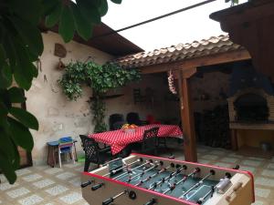 a ping pong table in a patio with a table and a tablecloth at CASA RURAL EL SALIDERO in Fuentidueña