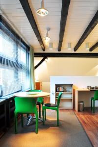 ein Esszimmer mit einem Tisch und grünen Stühlen in der Unterkunft Suite „Niedersachsen“ - wunderschönes Apartment in Fachwerkhaus in Hannover