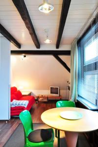 ein Wohnzimmer mit einem Tisch und grünen Stühlen in der Unterkunft Suite „Niedersachsen“ - wunderschönes Apartment in Fachwerkhaus in Hannover