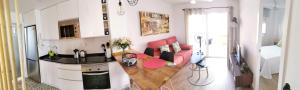 cocina y sala de estar con sofá rojo en una habitación en Apartamento Benidorm, en Benidorm