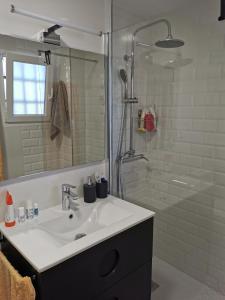 a white bathroom with a sink and a shower at Apartamento Benidorm in Benidorm