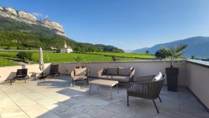 a patio with chairs and a couch and a table at Highlight Apartments in Appiano sulla Strada del Vino