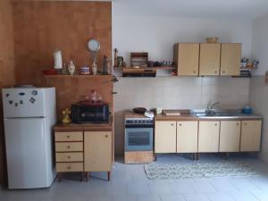 una piccola cucina con frigorifero e lavandino di casa panoramica a Calatabiano