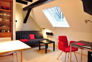 a living room with a couch and red chairs at Suite „Hannover“ - modernes Apartment in Fachwerkhaus in Hannover