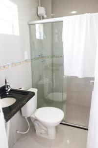 a bathroom with a shower and a toilet and a sink at Pousada Porto Sol in Porto De Galinhas