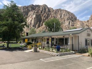 a building in a parking lot with a mountain in the background at Meadowcliff Lodge Coleville in Coleville