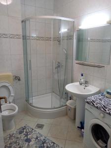 een badkamer met een douche, een toilet en een wastafel bij Vodice Mladen apartman za familiju in Vodice