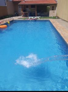 uma grande piscina azul com um disco de frisbee em Casa de chácara aconchegante para temporada em São Pedro