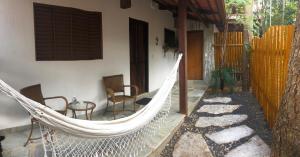 a hammock in a house with a table and chairs at Casa de São Jorge in Pirenópolis
