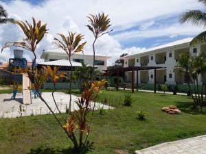 a resort with palm trees and a building at Areia do Atlantico Hotel in Porto Seguro