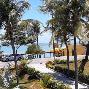 a parking lot with palm trees in front of a building at Areia do Atlantico Hotel in Porto Seguro