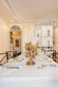 ein Esszimmer mit einem Tisch und einem weißen Tischtuch in der Unterkunft Luxury, Calm and Elegance in the heart of Champs-Elysées with a bottle of Champagne upon your arrival !!! in Paris