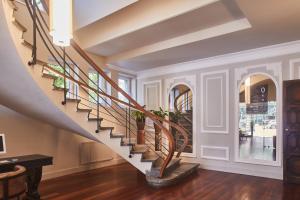 una escalera en una casa con paredes blancas y suelo de madera en Hotel Silken Palacio Uribarren, en Lekeitio