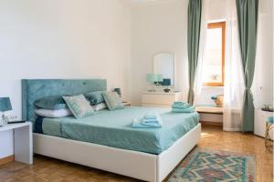 - une chambre avec un lit doté de draps bleus et une fenêtre dans l'établissement La Stella dei Venti B&B, à Naples