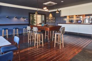a bar with a wooden table and bar stools at Hotel Silken Palacio Uribarren in Lekeitio