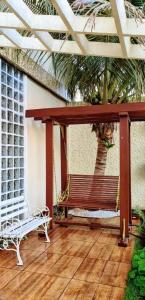a bench on a porch with a palm tree at Pousada Tamandaré in Campo Grande