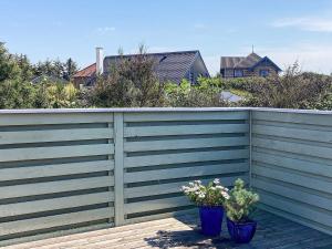 una valla con dos macetas en una terraza de madera en 6 person holiday home in R m en Lakolk