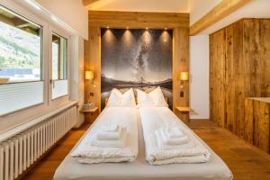 ein Schlafzimmer mit einem großen Bett mit einem Plakat an der Wand in der Unterkunft Ferienwohnung Haus Mia in Zermatt