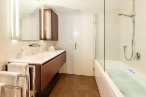 a bathroom with a tub and a sink and a shower at Ferienwohnung Haus Mia in Zermatt +53 photos