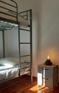 una camera con 2 letti a castello e un tavolo con una candela di Stone House - Sintra Rural a Sintra