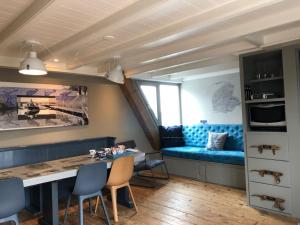 um quarto com uma mesa e um sofá azul em Elfstedenstate em Easterein