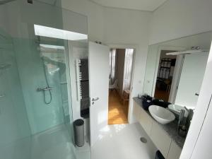 uma casa de banho com uma cabina de duche em vidro e um lavatório. em Porto.Leça - Studios and Apts (Apt D) em Leça da Palmeira