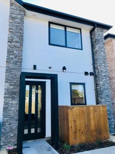 a house with a black door and windows at New Townhouse 5 min from central CHCH including bikes to use in Christchurch