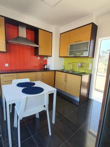 ブアルコスにあるFigueira Beach Apartmentのキッチン(白いテーブル、白い椅子付)
