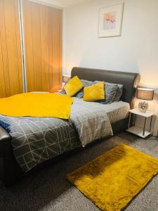 sypialnia z łóżkiem z żółtym kocem w obiekcie Best Stay - New Castle w mieście Newcastle under Lyme