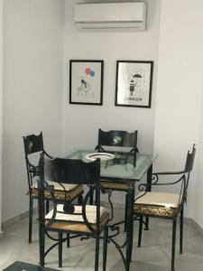 tavolo da pranzo con 4 sedie e tavolo in vetro di Apartamento Dos Faros a Conil de la Frontera
