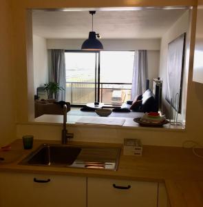 a kitchen with a sink and a large window at Rustig appartement met zeezicht dicht bij het centrum in Ostend