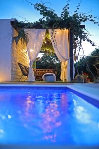 uitzicht op een zwembad met witte gordijnen bij Anchi Holliday House in Zadar