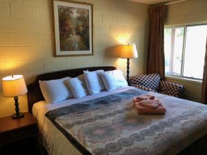 a bedroom with a bed with two lamps and a chair at Rolling Hills Motel in Wantage