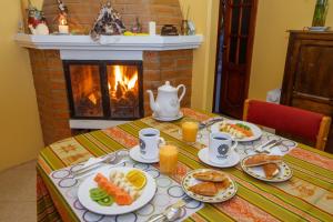 a table with plates of food and a fireplace at Casa de Luis in Otavalo