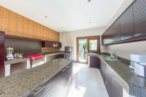 een grote keuken met granieten aanrechtbladen en roestvrijstalen apparatuur bij Villa Simone Bali in Ungasan
