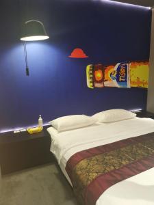 a bedroom with a bed and a blue wall at Hi Hotel in Singapore
