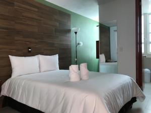 1 dormitorio con cama blanca y almohadas blancas en Malinalli Express, en Apizaco