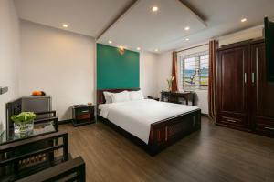 1 dormitorio con cama y pared verde en ĐỨC TRỌNG HOTEL en Hanoi