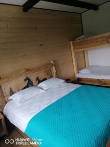 Habitación con 2 camas individuales y paredes de madera. en Cabana Agroturistica Runc en Borşa