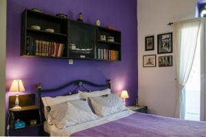 a purple bedroom with a bed and a book shelf at Balcony to the Aegean in Stení