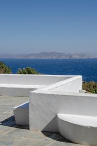 a white bench with the ocean in the background at Balcony to the Aegean in Stení