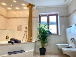 a bathroom with a tub and a toilet and a window at Ferienwohnung Vorberg in Schönau am Königssee +13 photos