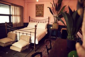 um quarto com uma cama e duas cadeiras e uma planta em The Mustang Nero Hotel em Banguecoque
