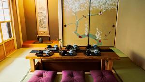 a room with a table and some chairs and a painting at Kokonoe Machiya in Kyoto