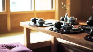 a wooden table with cups and plates on it at Kokonoe Machiya in Kyoto +38 photos