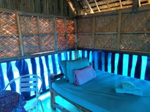 Cama azul en habitación con silla en SmallFry's Beach Resort en Calatrava