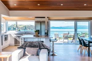 cocina y sala de estar con vistas al océano en Ocean View, en Te Whau Bay